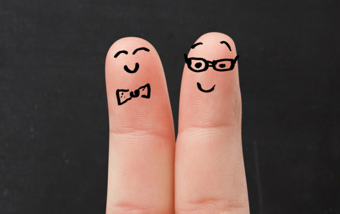 Dois dedos lado a lado com desenhos de rostos sorridentes.