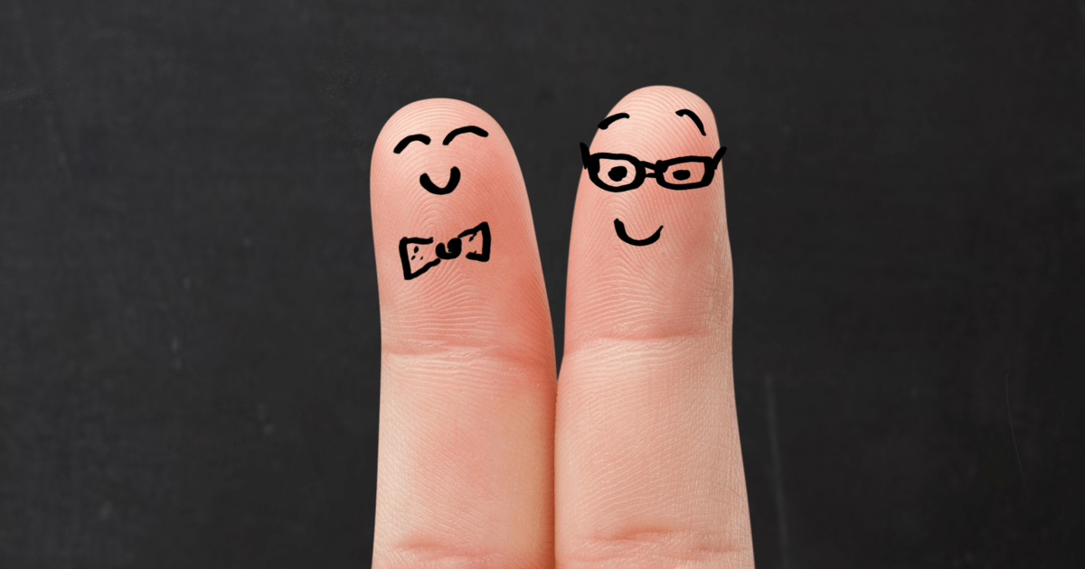 Dois dedos lado a lado com desenhos de rostos sorridentes.
